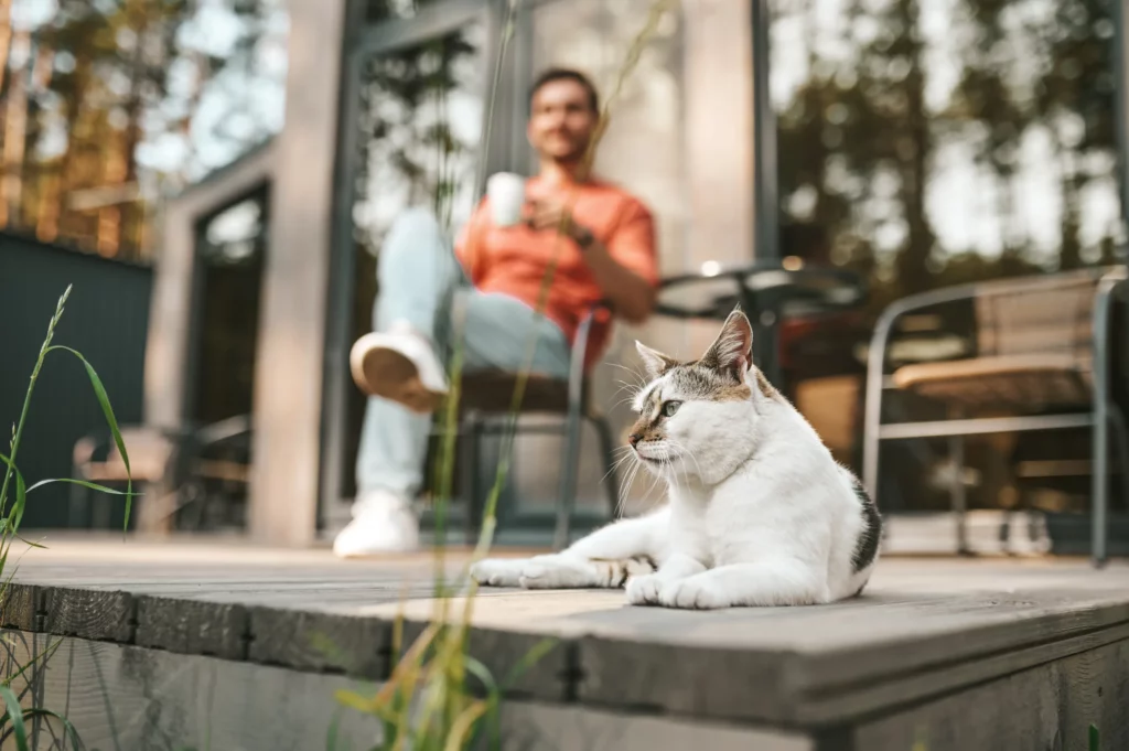 Kattunge eier på verandaen og slapper av med kaffe